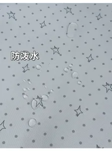 Gros plan sur des gouttes d’eau sur un tissu gris clair déperlant à motifs de pois et d’étoiles