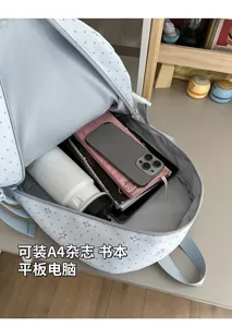 Sac à dos ouvert montrant un espace pour livres, magazine A4, tablette, téléphone et thermos