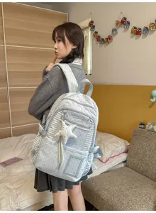 Vue de dos d’une élève portant un sac bleu clair à pois, avec des empiècements rayés et une étoile suspendue
