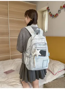 Vue arrière d’une élève portant un sac bleu clair avec poche transparente et breloque étoile