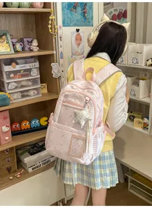 Vue de dos d’une élève portant un sac rose à étoiles, avec poche transparente et breloque