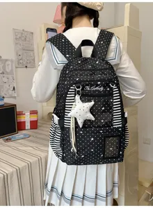 Vue de dos d’un sac à dos noir à pois et étoiles, côtés rayés et pendentif étoile en peluche