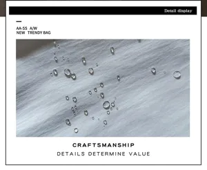 Gros plan sur des gouttes d’eau visibles sur le tissu gris clair à la texture légèrement mate