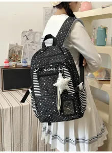 Vue arrière du sac noir à étoiles, avec panneaux rayés, poche transparente et breloque blanche