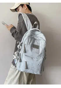 Vue de dos d’une personne portant un sac à dos bleu clair à étoiles avec pendentif étoile argenté