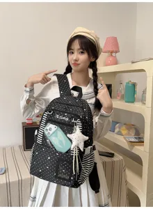Modèle portant un sac à dos noir à étoiles, avec rayures et pendentif étoile blanc suspendu