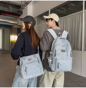 Deux modèles montrent de dos un sac à dos et un sac porté épaule à étoiles dans un passage urbain.