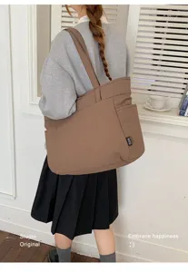 Vue de dos d’un modèle portant un sac en tissu brun spacieux avec une poche latérale