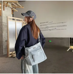 Sac bandoulière bleu clair à motifs d’étoiles, poche avant zippée et breloque étoile portée