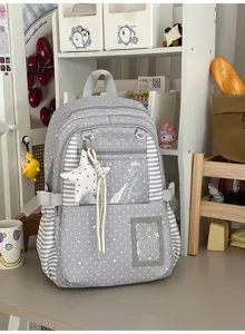 Détail du tissu gris à pois, rayures, poche frontale transparente et pendentif étoile