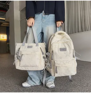 Modèle portant un sac à dos crème à étoiles et son cabas assorti, avec détails gris en intérieur