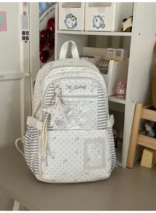 Détail du sac blanc à étoiles, avec panneaux rayés, poche transparente et breloque étoile