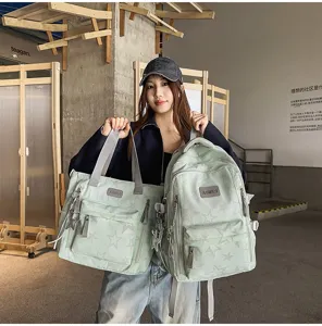 Une modèle présente deux sacs vert pâle à étoiles, avec poignées grises et breloques métal.