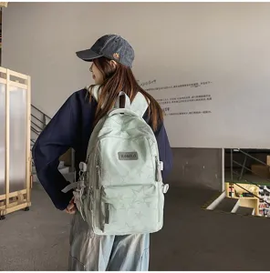 Vue de dos d’un mannequin portant un sac vert clair à étoiles, avec poches avant et fermetures zippées