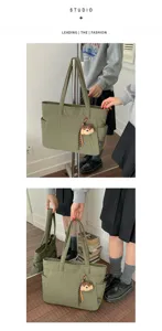 Sac vert en nylon avec poche latérale et breloque peluche, porté à la main ou à l’épaule