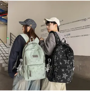 Deux modèles montrent de dos des sacs à dos menthe et noirs à motif étoilé avec breloques étoile