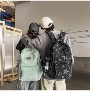 Deux personnes vues de dos avec sacs à dos étoilés vert menthe et noir, avec breloques étoilées