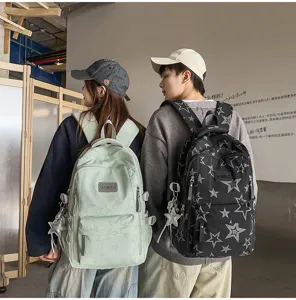 Deux personnes portent des sacs à dos étoilés, vert clair et noir, avec poches zippées