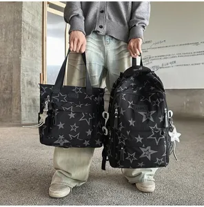 Une personne tient deux sacs noirs en nylon, imprimés d’étoiles grises avec des breloques étoilées