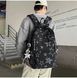 Vue de dos d’une personne portant un sac noir à étoiles, avec plusieurs zips et un pendentif étoile