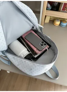 Sac ouvert avec téléphone, carnet et bouteille; tissu bleu clair à pois et étoiles bien visible