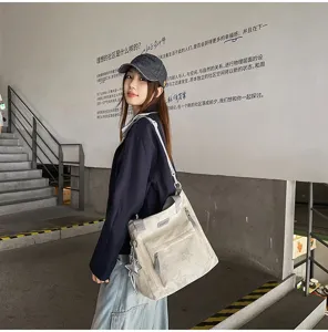 Un modèle porte un sac écru à imprimé étoilé, avec poches avant et breloque étoile pendante