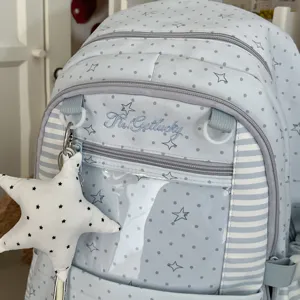 Sac à dos scolaire bleu clair avec pois gris, étoiles, côtés rayés et poche avant transparente