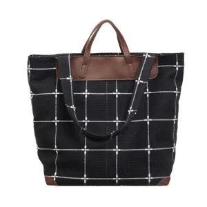 Schwarze Canvas-Tasche mit Karomuster, braunen Kunstledergriffen und Schulterriemen, geräumig