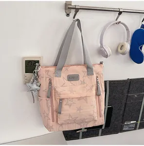 Sac cabas rose à motif d’étoiles grises, anses grises, poches avant zippées et breloque étoile