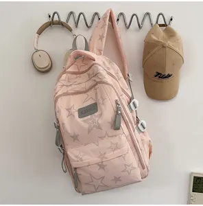 Sac rose en nylon à étoiles grises, poche avant, zips gris et bretelles en maille