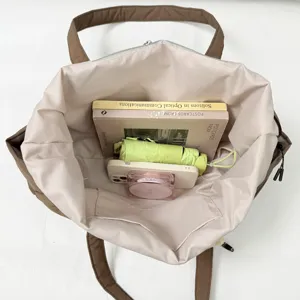 Grand cabas brun et beige avec fermeture zippée, anses et bandoulière, doublure claire