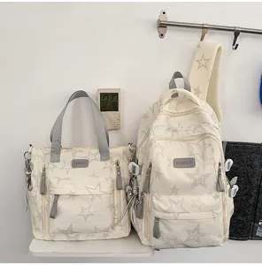 Deux sacs crème à étoiles grises, avec fermetures éclair et breloques métalliques, côte à côte
