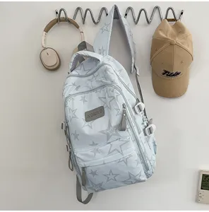 Sac à dos bleu clair à étoiles suspendu au mur, avec fermetures éclair grises et bretelles