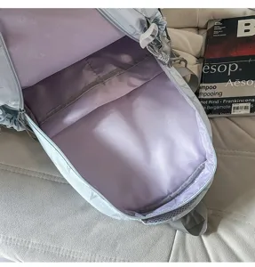 Intérieur du sac à dos bleu clair avec doublure lavande, compartiment séparé et poche intérieure zippée