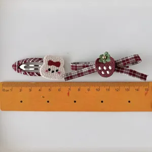 Pair of children's red plaid hair clips with embroidered bear and strawberry decorations