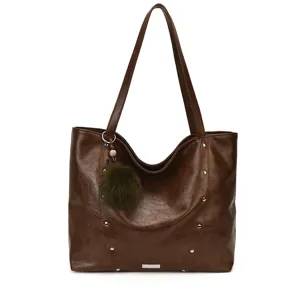 Large brown PU leather tote bag with long shoulder straps, silver studs and a green pom-pom