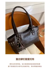 Vista de un bolso marrón oscuro texturizado con tachuelas, colgante de estrella y adornos de cuentas