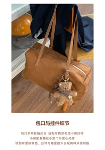 Detalle del bolso marrón de ante con cremallera y colgante de oso con pañuelo de cuadros