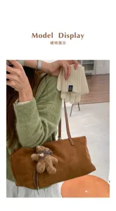 Jersey verde, guantes de punto color crema y bolso de ante marrón con colgante de osito de peluche