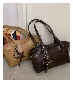 Dos bolsos tote de estilo vintage, en beige y marrón oscuro, con tachuelas, asas largas y estrellas