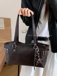 Bolso de hombro de piel sintética marrón oscuro, con asas largas, tachuelas y colgante de estrella