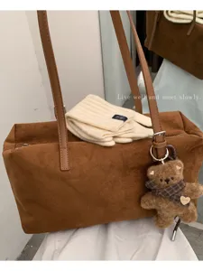 Bolso bandolera marrón de efecto ante y forma de cojín, con asas largas y un colgante de osito