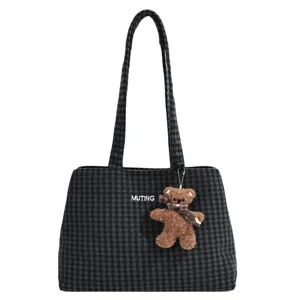 Front view of a dark gray plaid tote with white lettering and a brown teddy bear charm