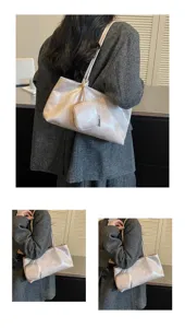 Detalle del bolso gris plateado al hombro, con un pequeño monedero con cremallera a juego