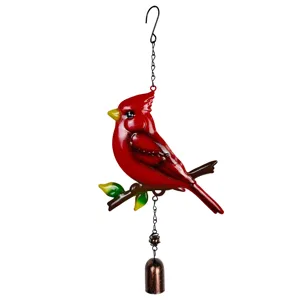 Vista frontal de un cardenal rojo de metal sobre una rama, con cadena y campana de bronce envejecido