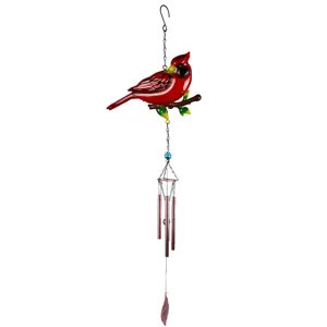 Cardenal rojo posado en una rama sobre tubos metálicos de campana y un colgante con forma de hoja.