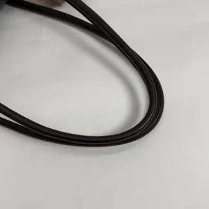 Primer plano de una correa de bolso marrón oscuro, lisa y efecto cuero, curvada en forma de aro