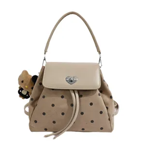 Front view highlighting beige dotted texture, heart-shaped clasp, drawstring trim and bear charm