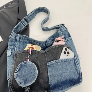 Flat lay close-up of a blue and black denim bag with multiple pockets and a round coin pouch