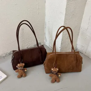 Dos bolsos de ante sintético, color café y caramelo, con asas de hombro y adornos de osito